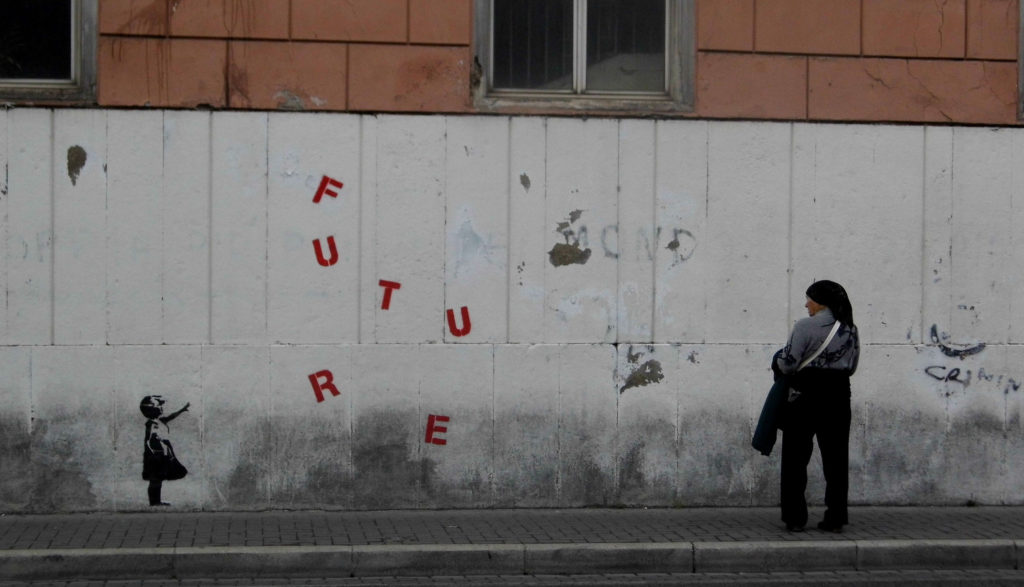 Kobieta patrzy na mur z napisaem Future